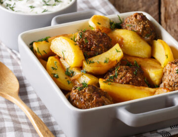 Potato wedges and meatballs, herbs in a dish close-up on the table. Horizontal